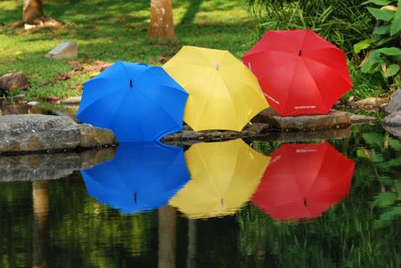 colorful umbrella reflection at the pond side の写真素材