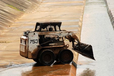 worker and tractor cleaning the big drainの写真素材