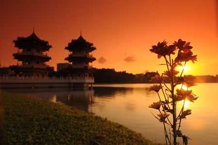 sunset, flower and pagoda at the lake sidesの写真素材