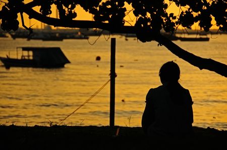 woman seating at the seasideの写真素材