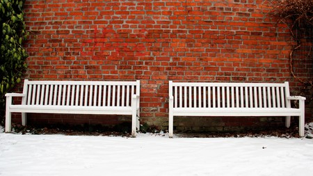 Brick wall with two white bench in winter. Cottbus Germanyの写真素材