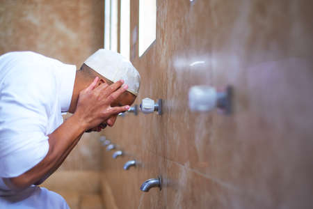 A Muslim man cleansing his ears in the washroomの写真素材