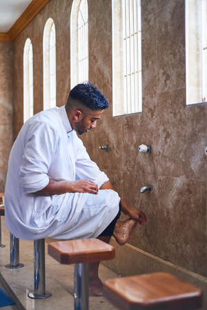 A Muslim man cleansing his feet in the mosque washroom