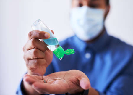 A businessman squeezes hand sanitiser into his palmの写真素材