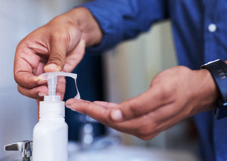 Close up side view of soap being dispensed in the bathroomの写真素材