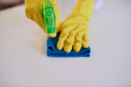 A cleaning professional sprays a kitchen counter with sanitiserの写真素材