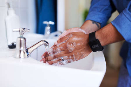 Close up shot of a businessman washing his hands in the bathroom sinkの写真素材