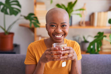 A young woman makes a cup of rooibos or red bush tea for health and wellness