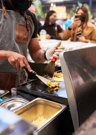 Close up shot of a chef cooking chicken for tacos at a food marketの写真素材