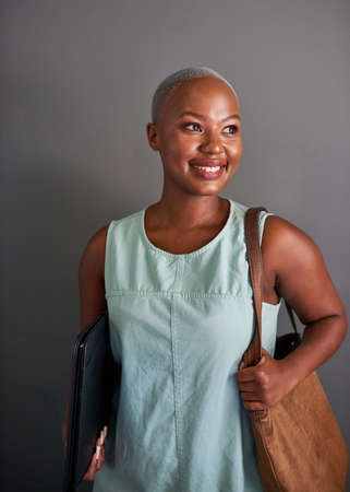 A young attractive Black businesswoman arrives at the office with handbagの写真素材