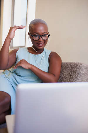 A young Black woman illustrates with her hands during a conference call