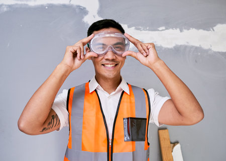A construction worker fits his safety goggles while on siteの写真素材