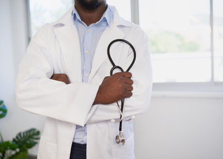 Cropped shot of Black doctor holding stethoscope in folded armsの写真素材