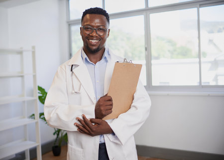 Portrait of a Black doctor holding clipboard with patient informationの写真素材