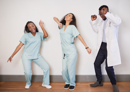 Team of three medical professionals dance on a break, doctor having funの写真素材