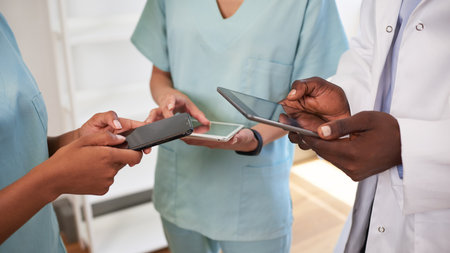 Cropped wide shot of doctors hands using digital tablets in scrubs at hospitalの写真素材