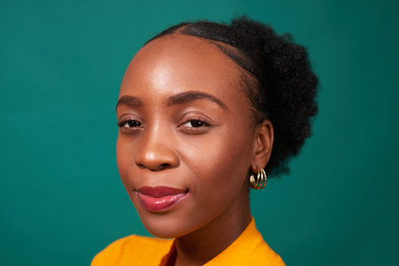 Beautiful Black woman, studio teal background, fashion lifestyle portraitの写真素材