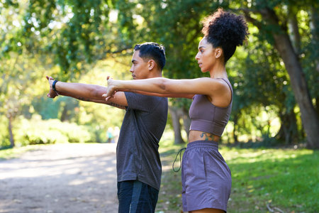 Beautiful couple stretch together before running in park, fitness trail runの写真素材