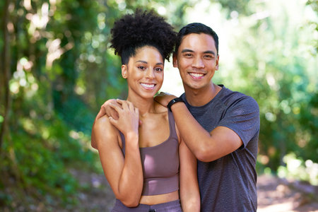 Happy young couple pose in forest in active wear, fitness trail run hikingの写真素材