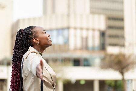 Happy Black Woman Embracing Success and Freedom in Urban Business Setting