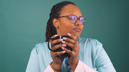Young Black female nurse drinks coffee and takes a break