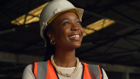 Smiling Black Female Engineer in Construction Site With Safety Gear and Hard Hat
