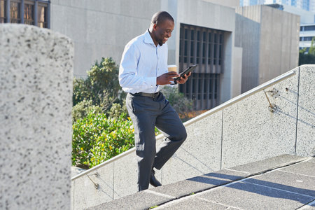 Businessman Walking with Coffee and Tablet Outdoorsの写真素材