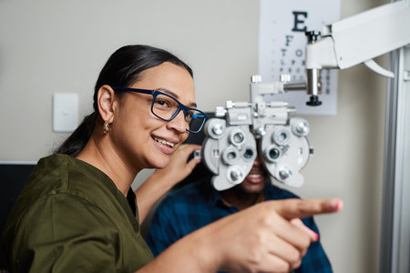 Friendly Optometrist Assisting a Patient with Eye Exam Using Modern Equipment in Clinic Setting