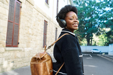 Young Woman Enjoying Music with Headphones While Walking in the Cityの写真素材