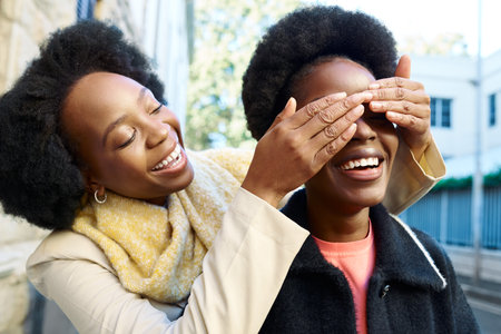 Joyful Surprise Moment Between Friends in a Sunny Urban Setting With Laughter and Happinessの写真素材
