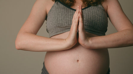 Pregnant Woman Practicing Mindful Yoga With Hands in Prayer Pose