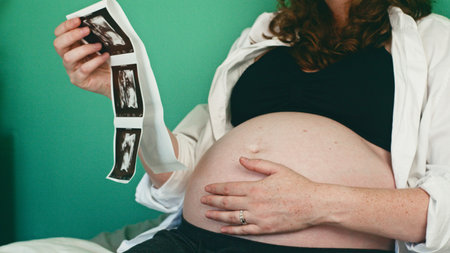 Pregnant Woman Holding Ultrasound Scan in a Relaxed Setting at Home