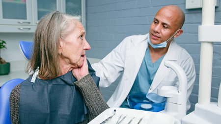 Senior Woman in Dental Clinic Consulting Dentist About Facial Complaints
