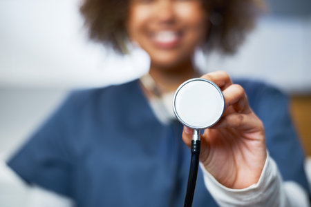 Close-Up of a Smiling Medical Professional Holding a Stethoscopeの写真素材