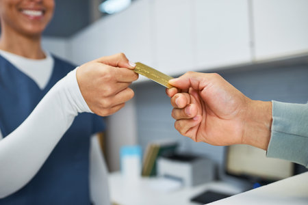 Healthcare Professional Receiving Credit Card Payment for Medical Services in Reception Area