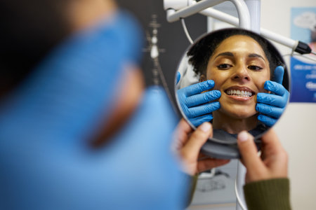 Smiling Patient Checking Reflection During Dental Check-Up with Dentist Assistance