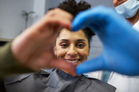 Patient Smiling at Dentist Visit Framed by Heart of Hands