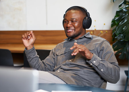 Man Smiling While Enjoying Music with Wireless Headphones in a Relaxed Setting