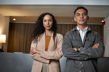 Confident Business Team Poses with Arms Crossed in a Modern Hotel Lobbyの写真素材