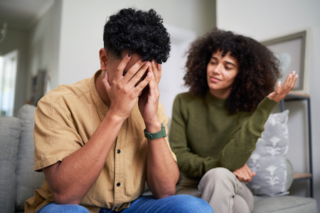 Worried Couple Sitting on a Couch at Home Having a Discussion
