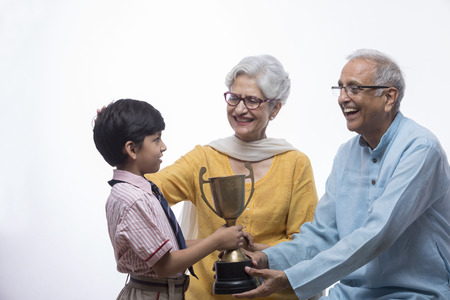 Boy showing trophy to grandparents