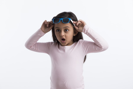Little girl giving a surprised look putting her goggles on her head.の写真素材