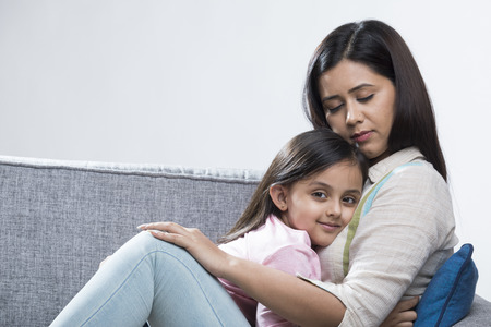 Mother and daughter relaxing on sofaの写真素材