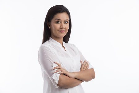 Portrait of woman wearing white top standing arms crossedの写真素材
