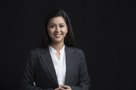 Portrait of smiling woman wearing black coatの写真素材