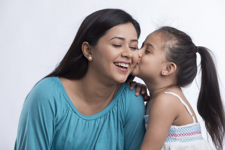 Portrait of daughter kissing motherの写真素材