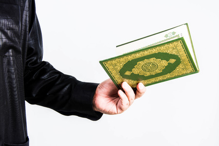 Koran in hand ,Quran in hand - holy book of Muslims , on white backgroundの写真素材