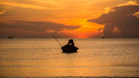 Silhouette of fishing boat at ?he Sunrise in thailandの写真素材