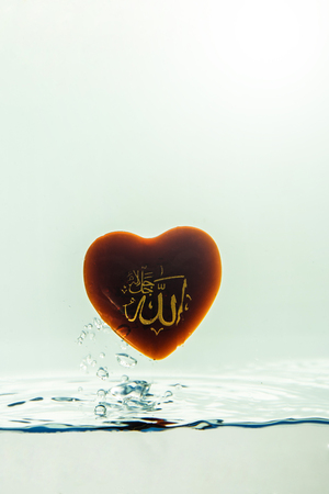 "allah" god of Islam with  ( symbol )  Water splash with bubbles of air, isolated on the white backgroundの写真素材