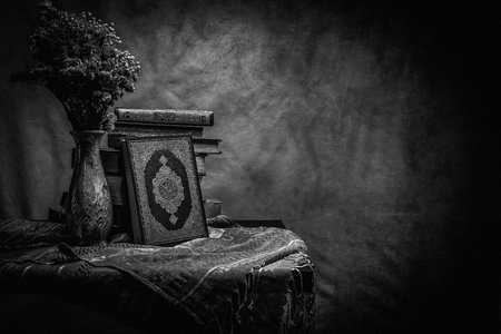 Koran - holy book of Muslims ( public item of all muslims ) on the table , still life . Monochrome or black and white の写真素材